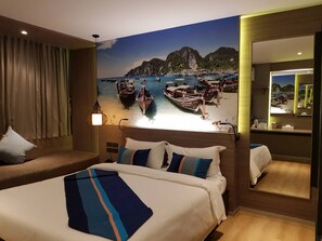Una habitación de hotel con cama, sofá, un amplio ventanal con vistas a barcos y montañas, y un espejo en la pared.