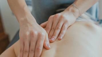 Une personne qui effectue un massage sur une autre personne.