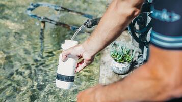 Une personne qui boit de l’eau dans une bouteille, porte un casque de cycliste et un maillot de cyclisme.