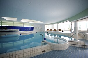 Una piscina techada, sillones reclinables de piscina