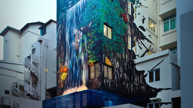 Un bâtiment orné d’une fresque représentant une cascade et une forêt.