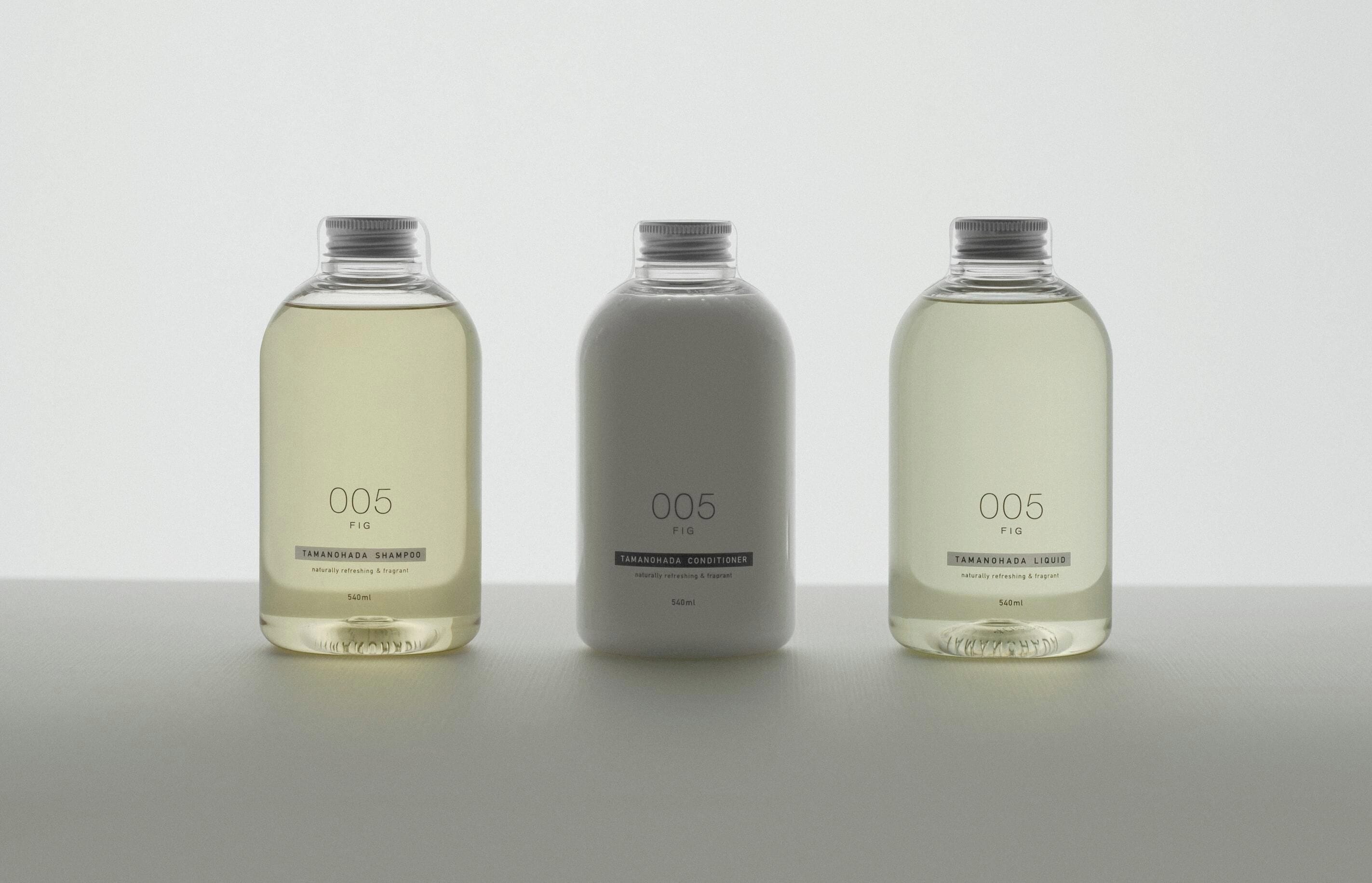 Drei Flaschen eines Produkts mit dem Aufdruck '005 FIG' und unterschiedlichen Flüssigkeiten.