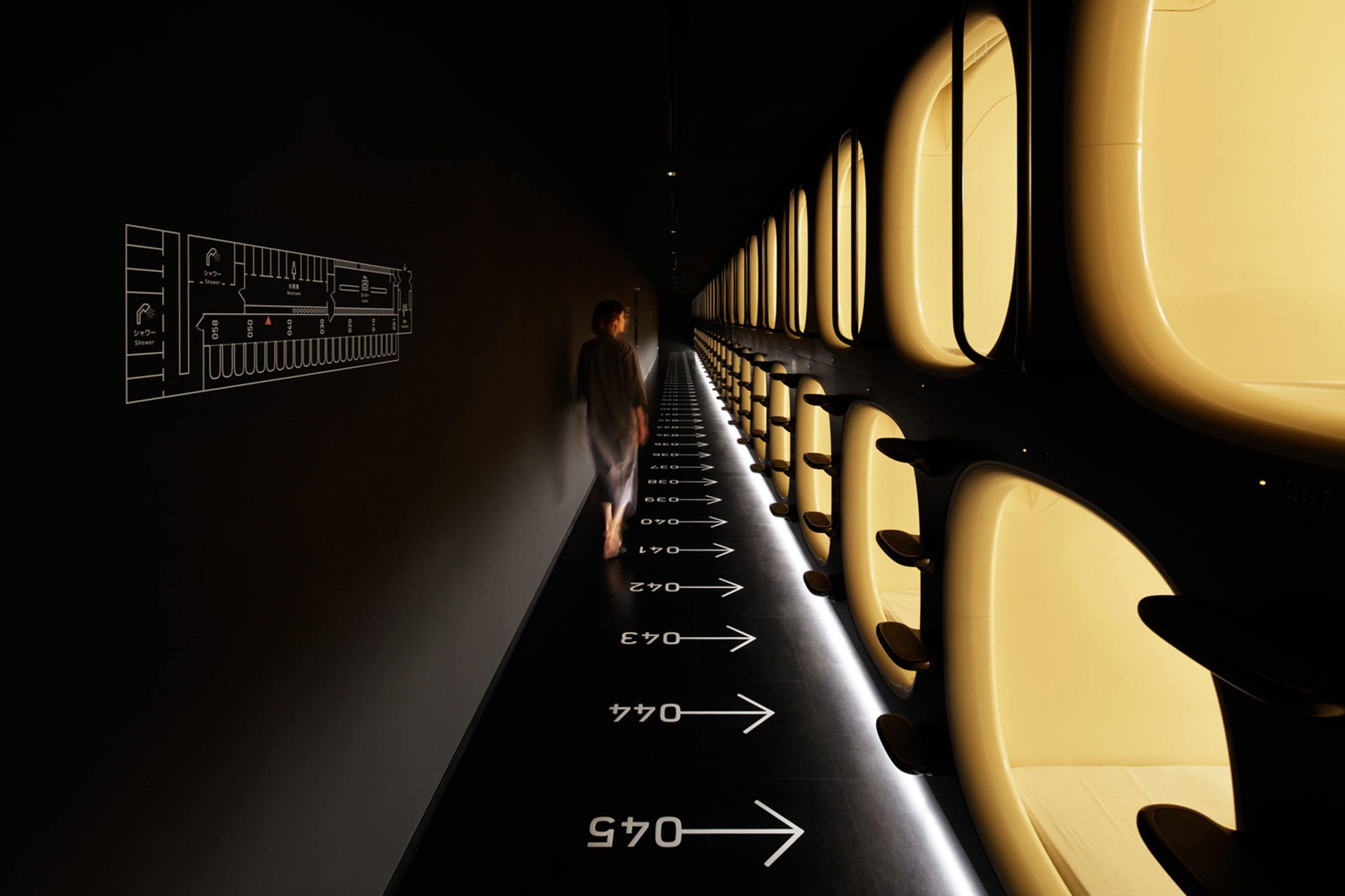 A narrow aisle with rows of airplane seats and directional arrows on the floor.