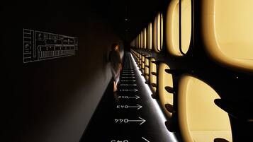 A narrow aisle with rows of airplane seats and directional arrows on the floor.