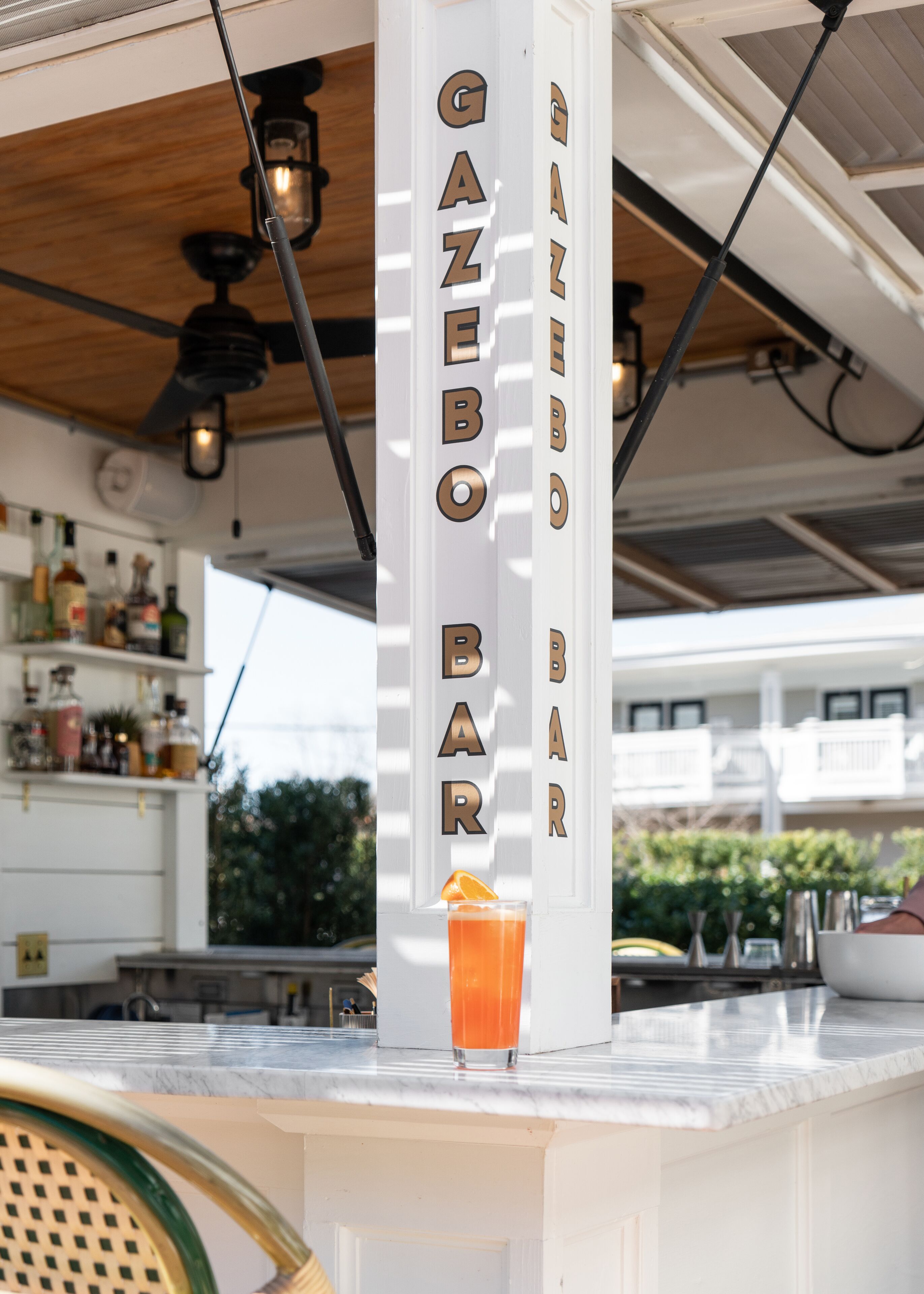 Um bar chamado GAZEBO BAR com uma bebida no balcão.