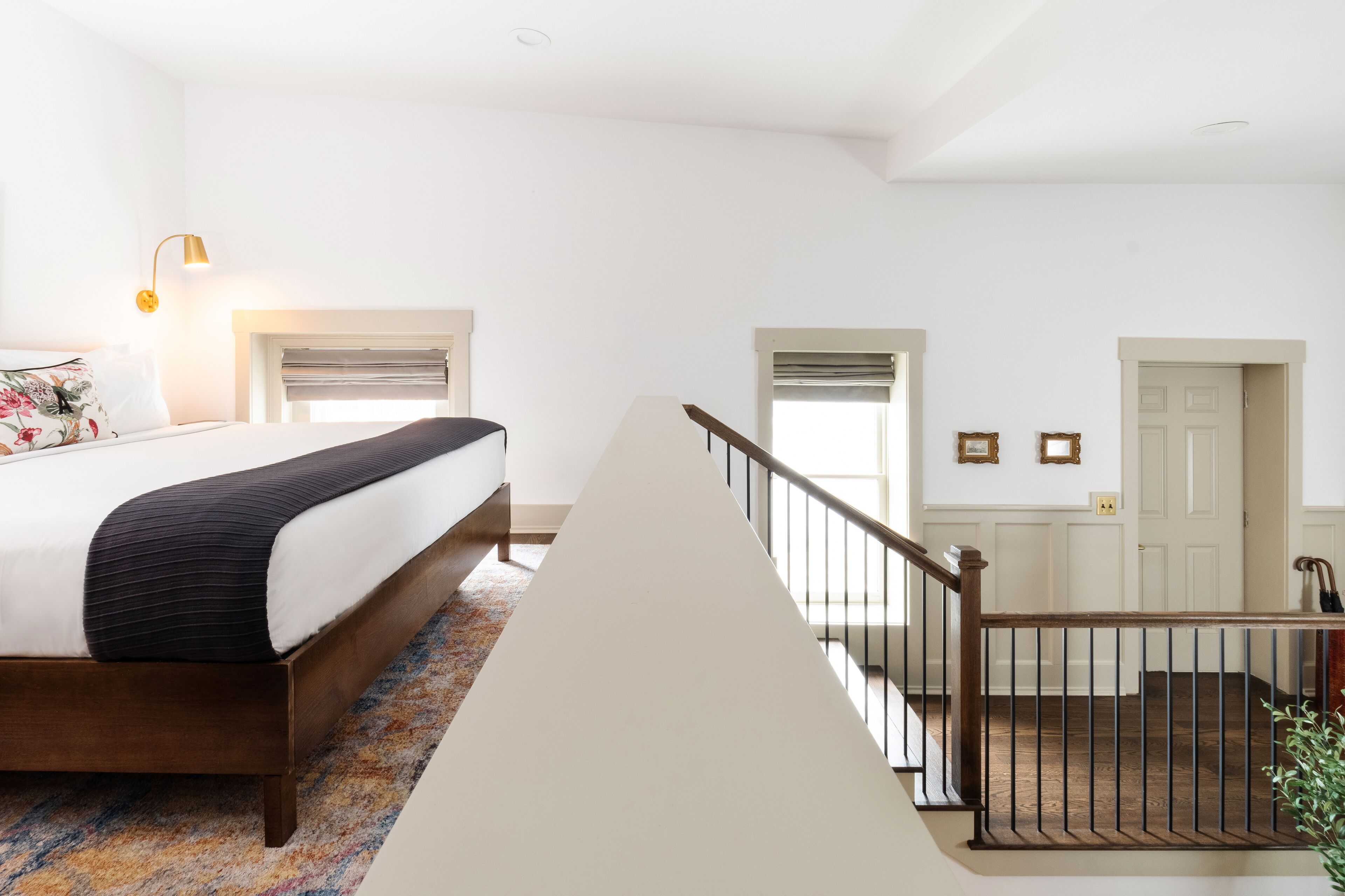 Una camera da letto con un letto, un comodino, una lampada e una finestra.