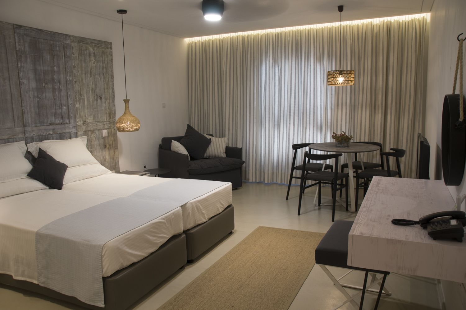 Ein modernes Hotelzimmer mit einem großen Bett, einem Schreibtisch und einem Essbereich.