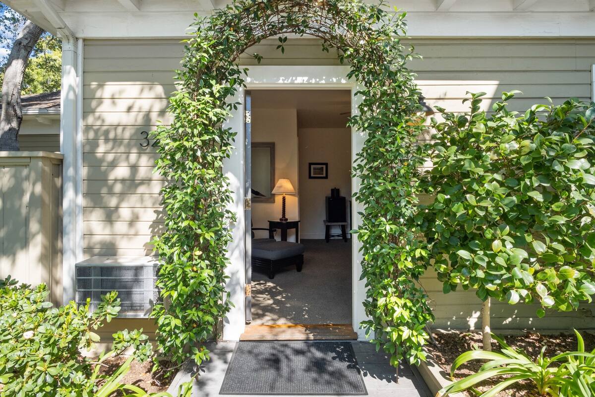 Une entrée de maison avec un porche abrité, une porte et un petit coin salon à l’intérieur.