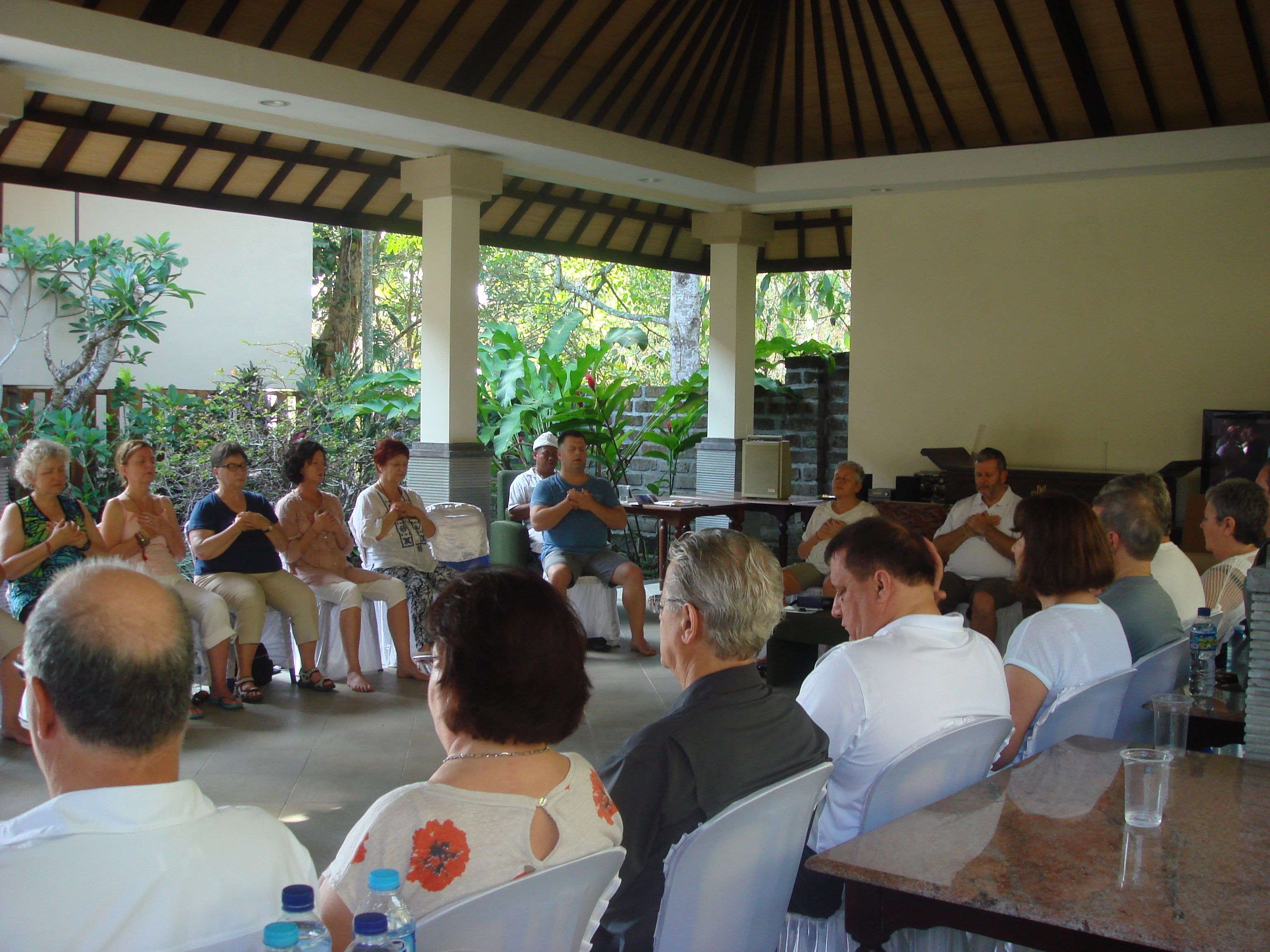 A covered outdoor seating area with people engaged in a group activity.