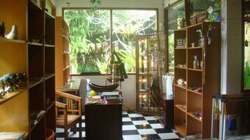 A room with a checkered floor, wooden furniture, and shelves filled with various items.