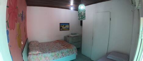 Un dormitorio pequeño con una cama individual, un aparador y un radiador.
