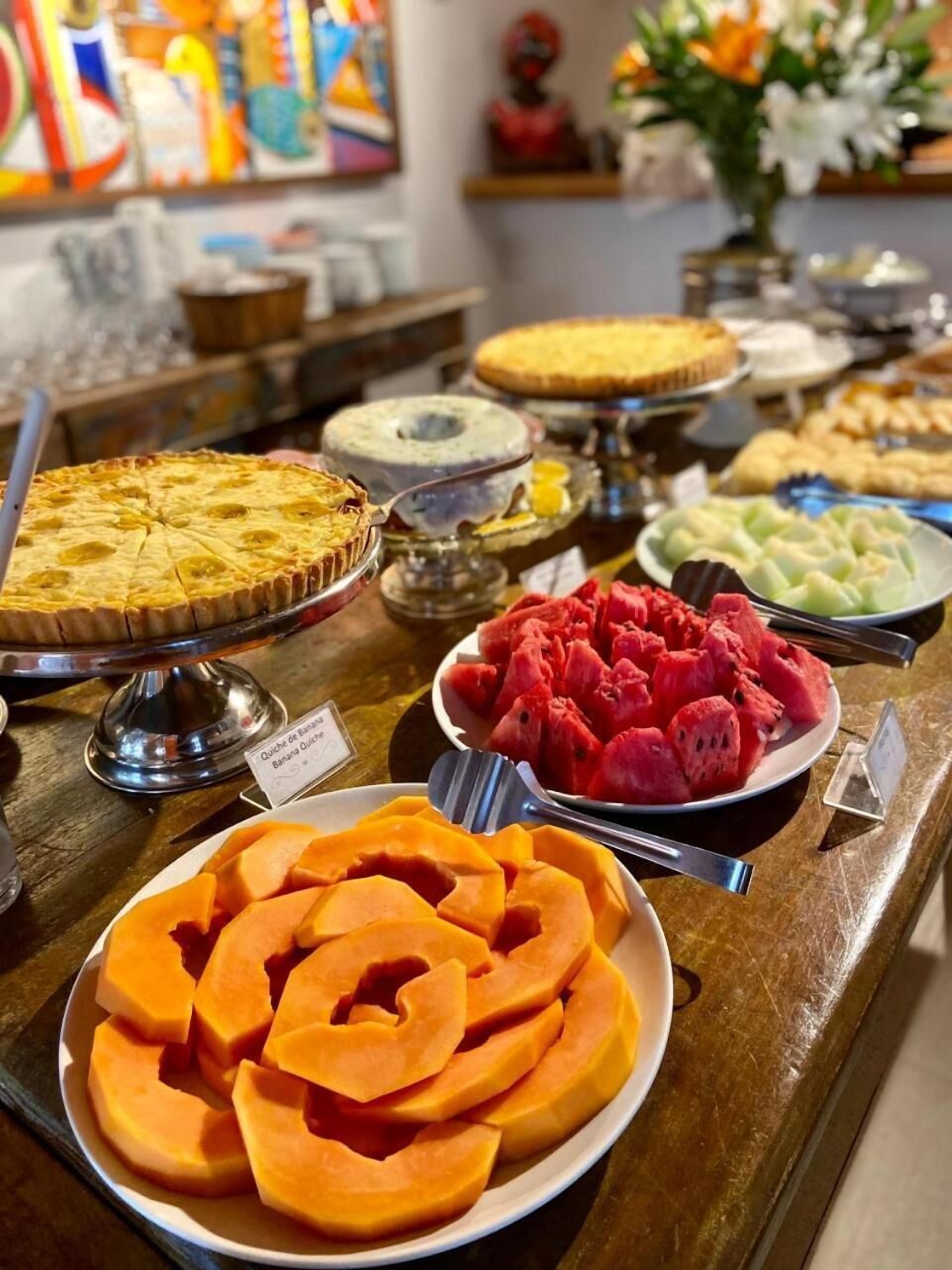 A buffet with various dishes including a quiche, watermelon, and cantaloupe.