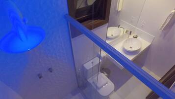 Et moderne badeværelse med to håndvaske, toilet og brusekabine i glas.