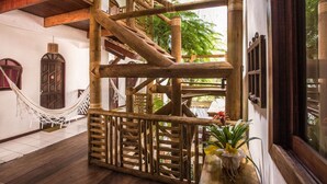 A wooden staircase with a hammock and a potted plant. - Pousada João Sol (Mata de São João)