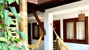 A wooden balcony with a hammock, a staircase, and a view of the surrounding area. - Pousada João Sol (Mata de São João)