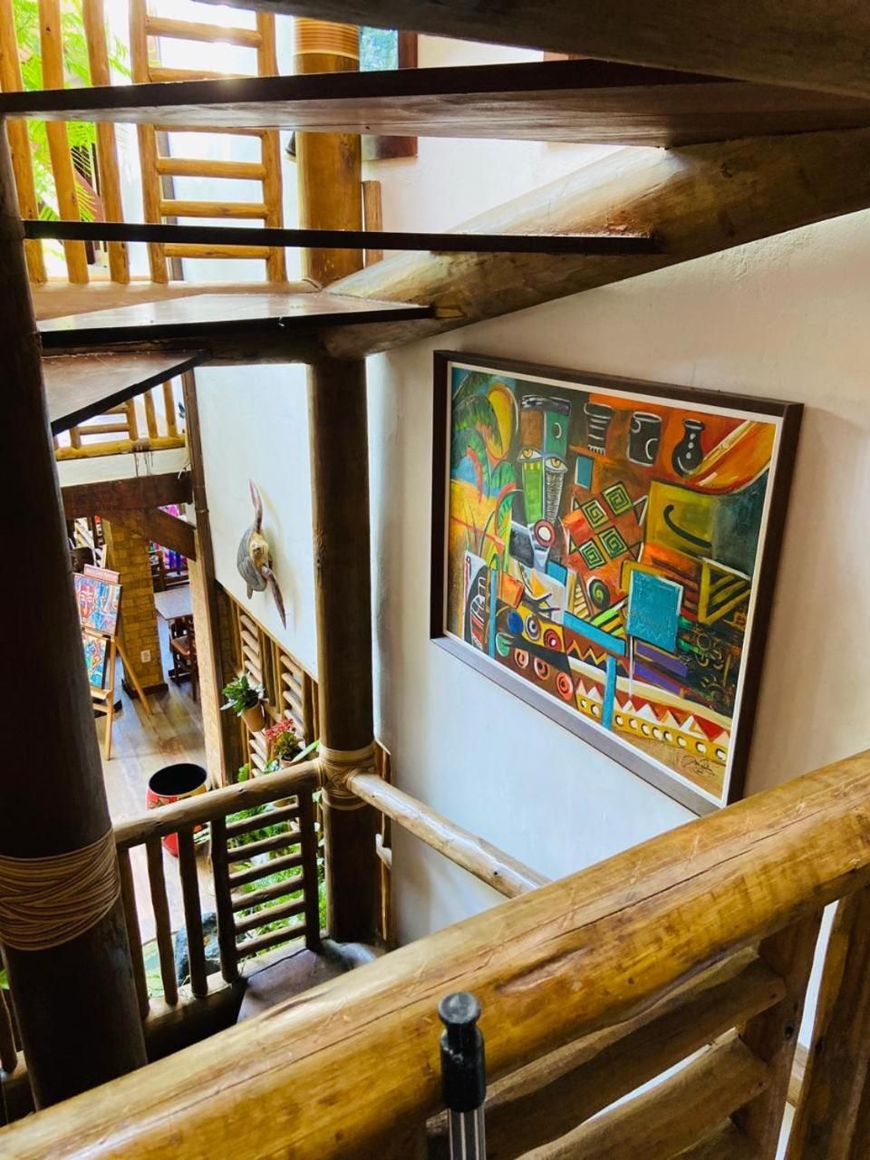 A wooden staircase with a colorful abstract painting on the wall.