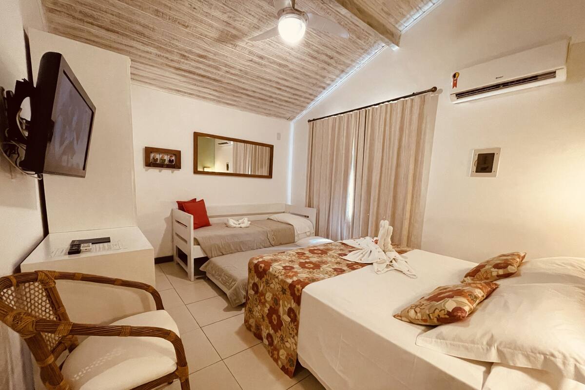 Een hotelkamer met een bed, een bureau, een stoel, een televisie en een spiegel.