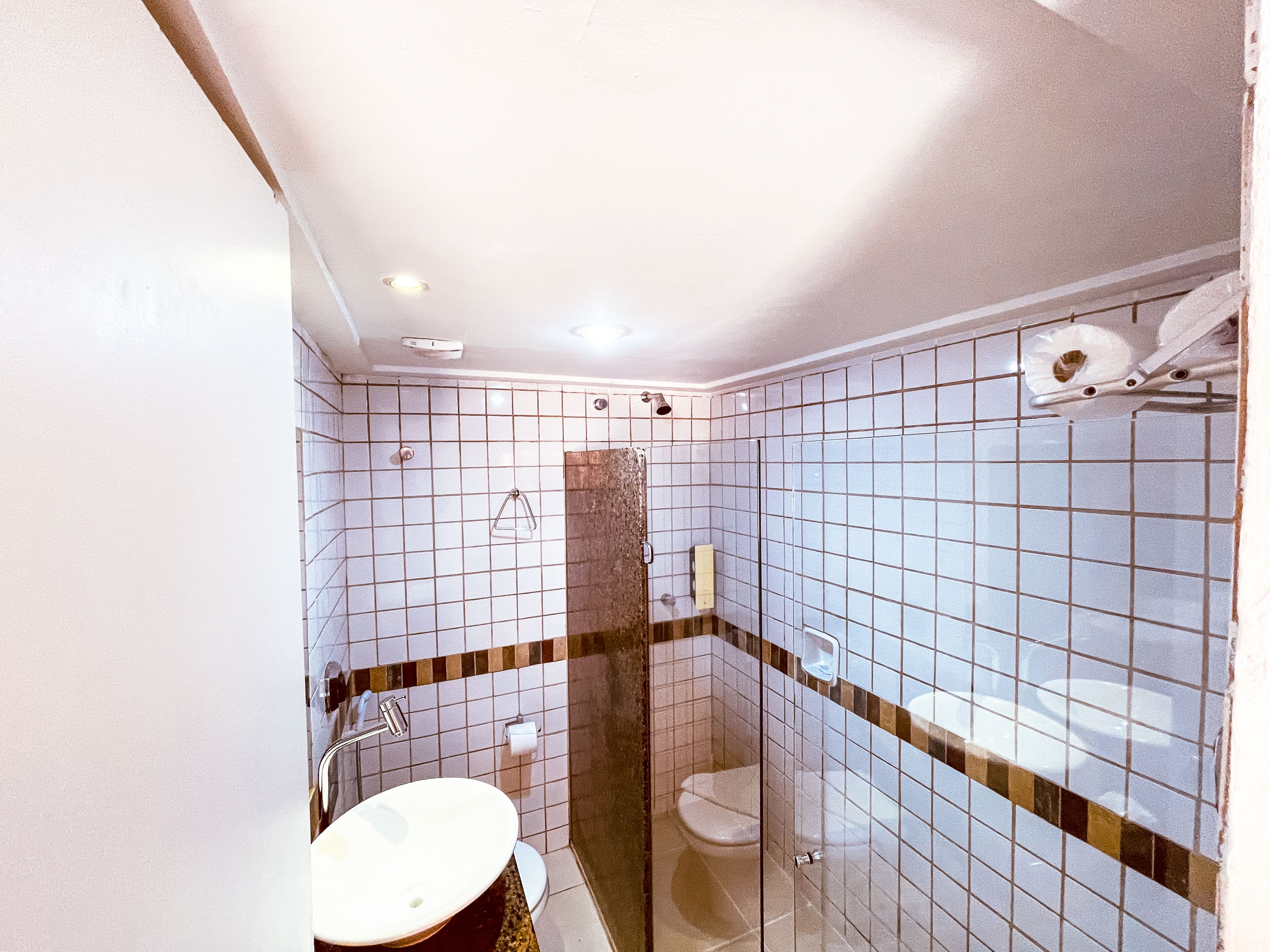 A bathroom with a sink, toilet, and shower area.