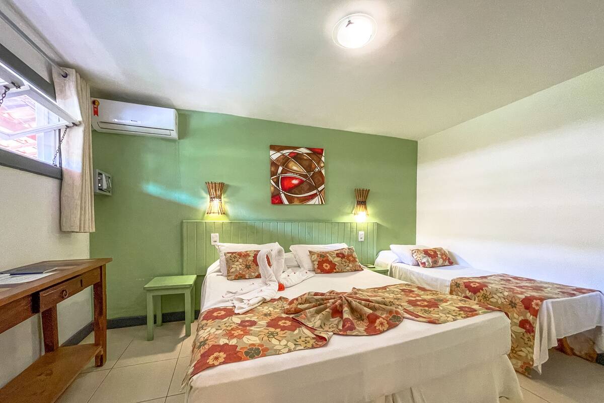 Een hotelkamer met twee bedden, een tafeltje en een nachtkastje.
