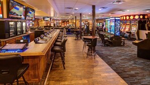 A casino with multiple gaming tables and slot machines, bar area with stools, and a carpeted floor. - Winners Inn Casino (Winnemucca)