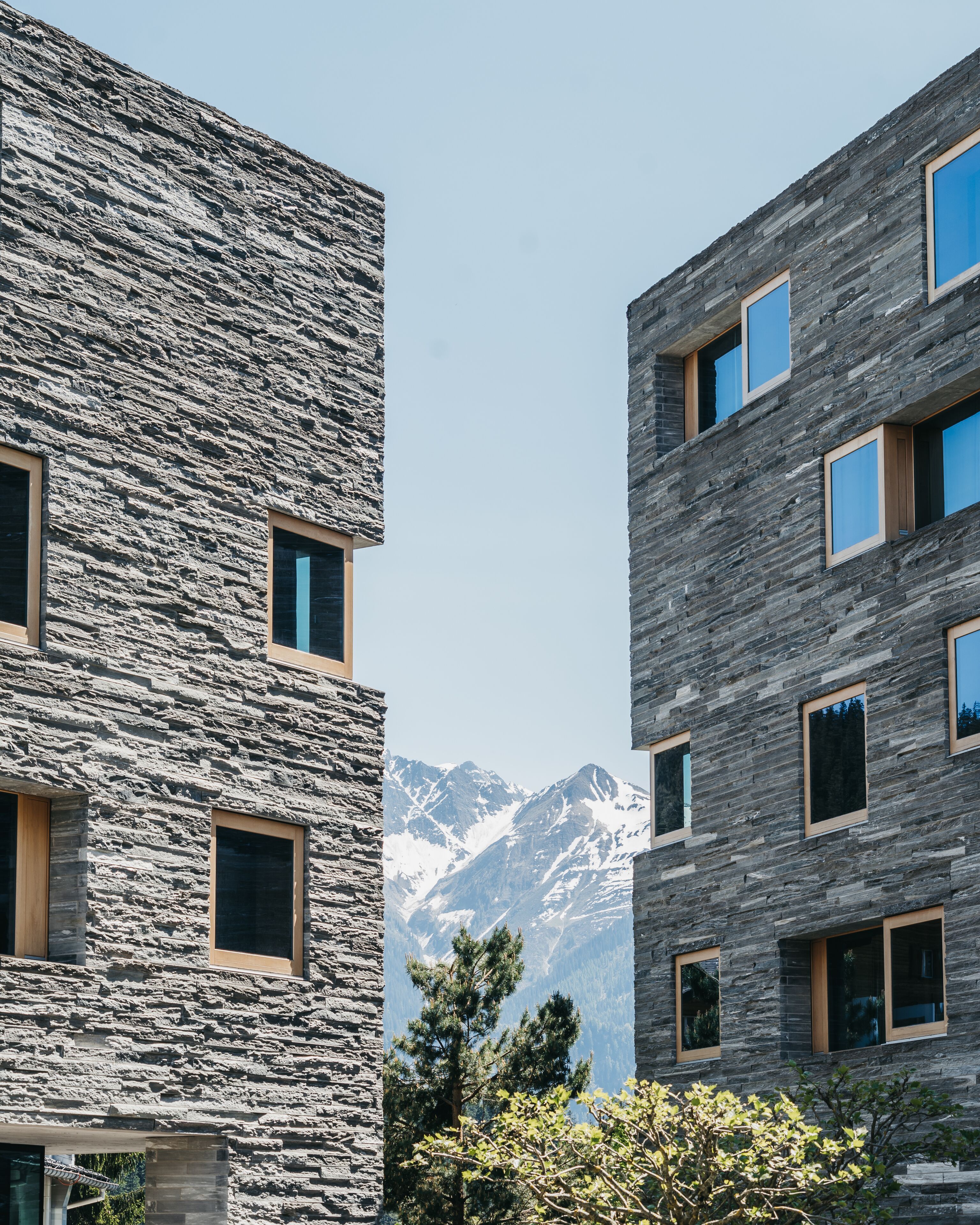 Un edificio moderno con fachada de piedra y varias ventanas.