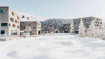 A modern residential area with multi-story buildings, a snow-covered landscape, and a clear sky.