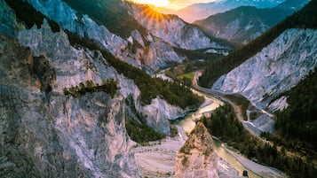 Eine gebirgige Landschaft mit einer kurvenreichen Straße und einem Fluss.
