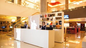 A hotel reception area with a modern design, featuring a reception desk, a staircase, and a bar area. - Fiesta Inn Queretaro Centro Sur (Querétaro)