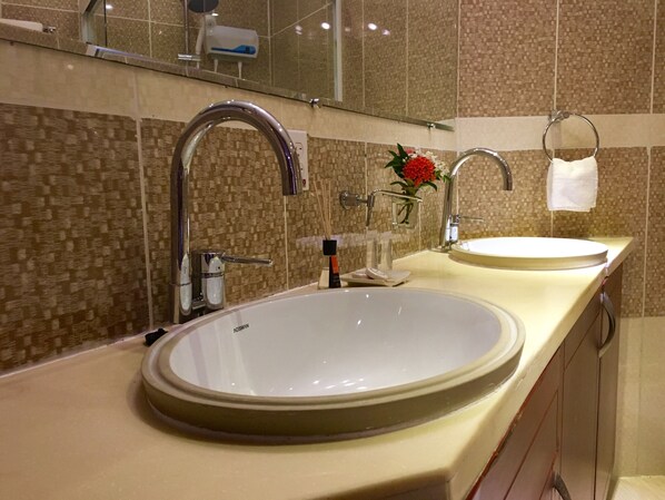 A modern bathroom with two sinks, a large mirror, and a towel rack. - Curacao Suites Hotel (Willemstad)