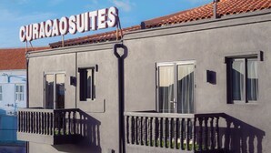 Un edificio con un cartel que dice "CURACAO SUITES" y balcones con barandillas.