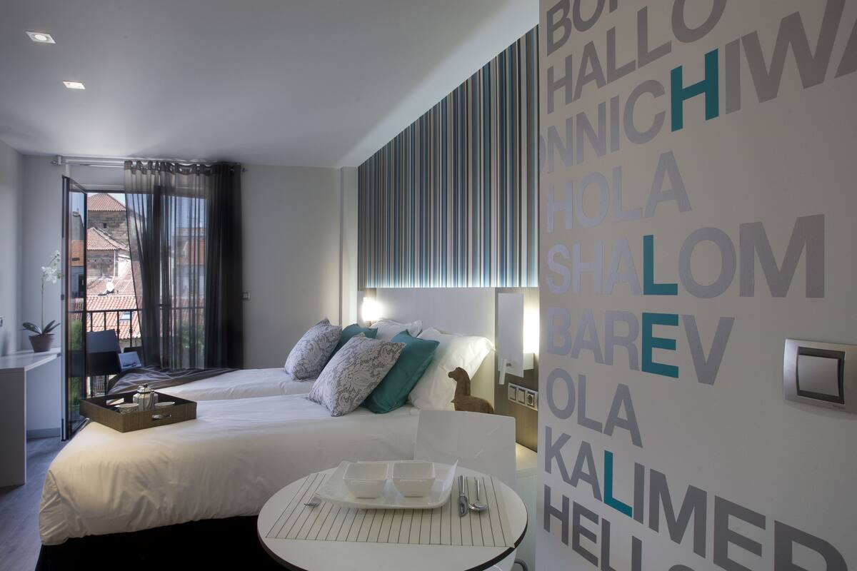 Een moderne hotelkamer met een bed, nachtkastje en stadszicht.