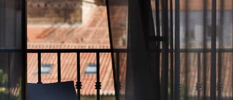 A balcony with a chair, a pair of glasses, and a piece of paper.