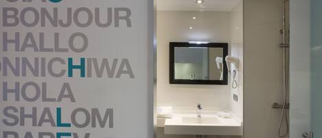 A modern bathroom with a sink, mirror, and shower.