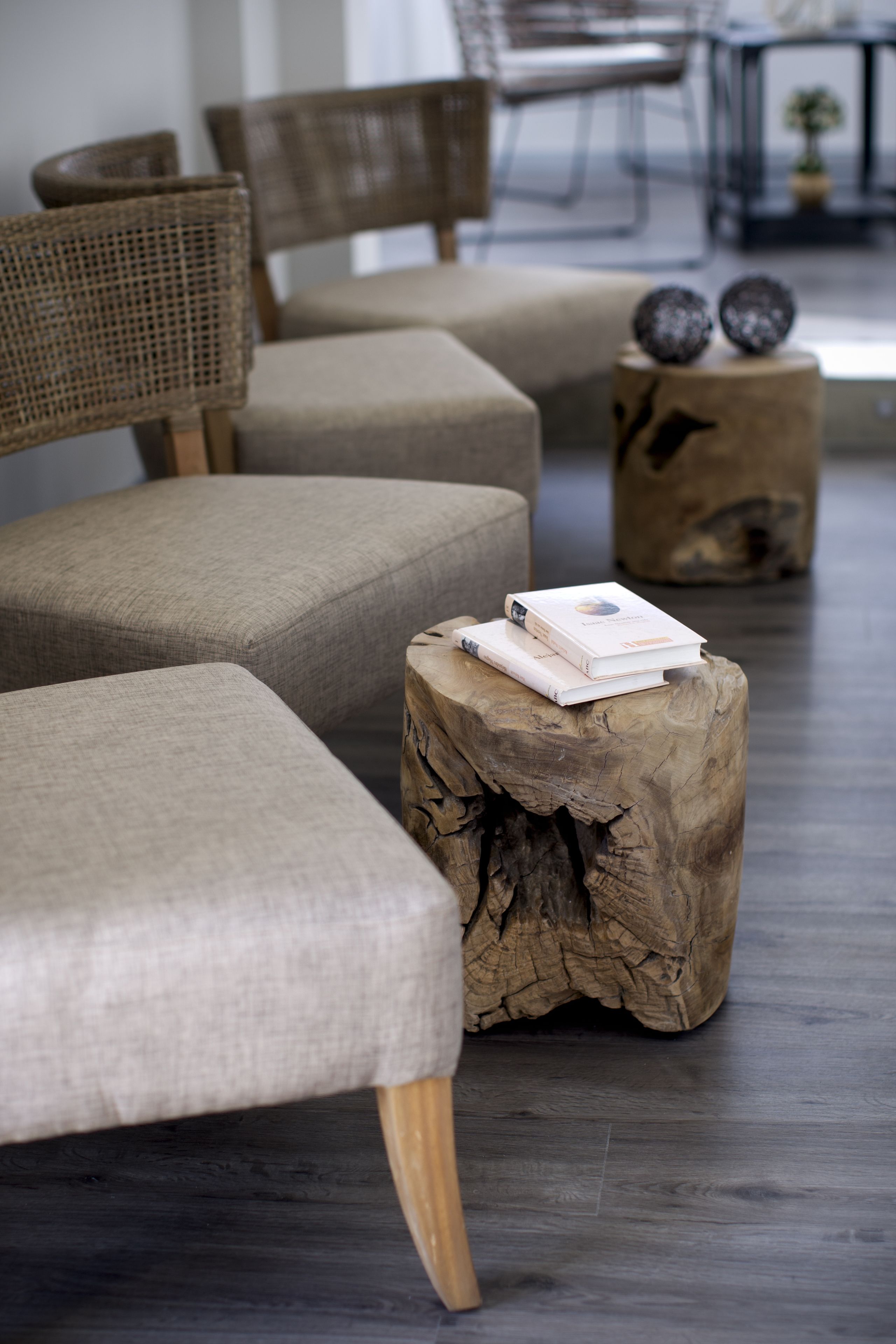 Una sala de estar moderna con un sofá, sillas y una mesa de centro de madera con libros.