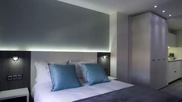 Un dormitorio moderno con una cama grande, dos mesitas de noche y un armario.