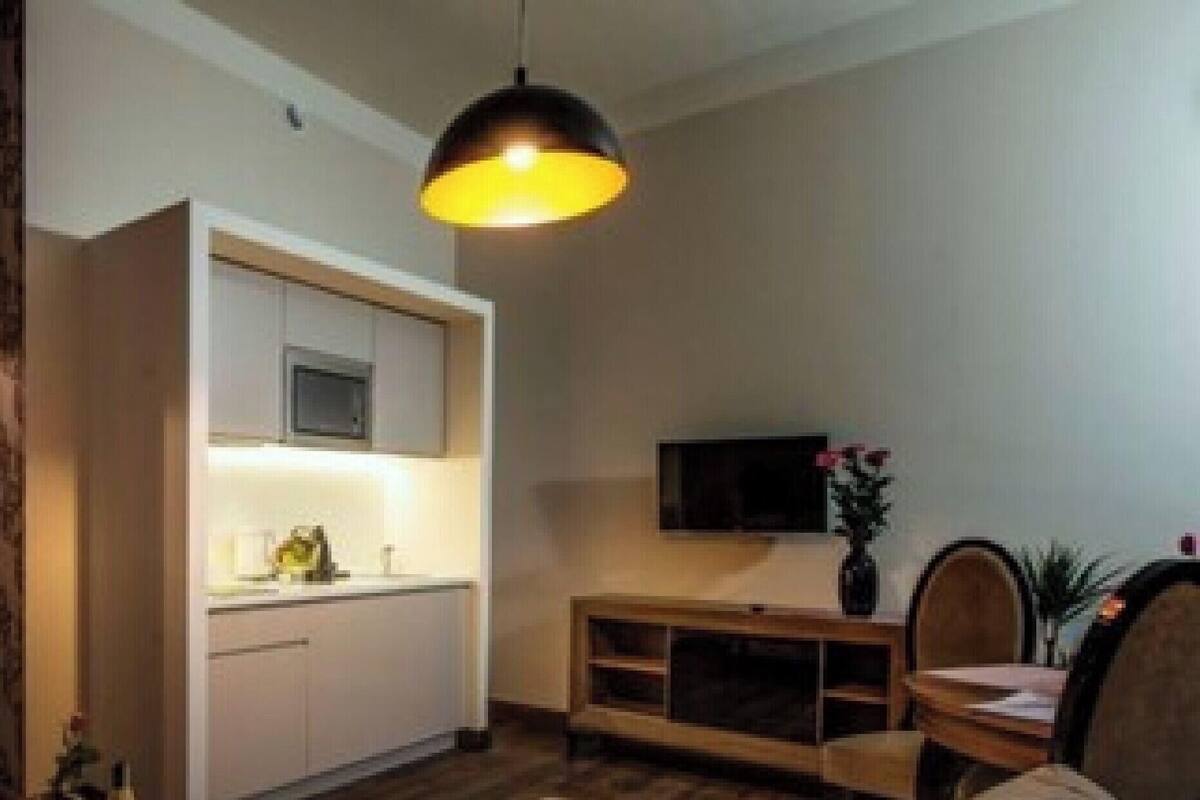 A compact living space with a kitchenette, a flat-screen TV, and a dining area.