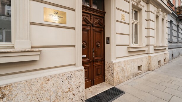 A building entrance with a double wooden door, a plaque reading "TOPOLOWA RESIDENCE," and a number "27" on the wall. - Topolowa Residence by StayLab (Kraków)