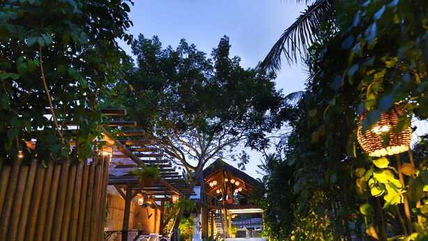 A garden pathway leading to a wooden structure with outdoor seating. - Pousada Enseada dos Golfinhos (Tibau do Sul)