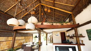 A spacious room with a high ceiling, wicker furniture, and hanging lanterns. - Pousada Enseada dos Golfinhos (Tibau do Sul)