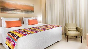 A hotel room with a bed, a chair, a desk, and a painting on the wall.