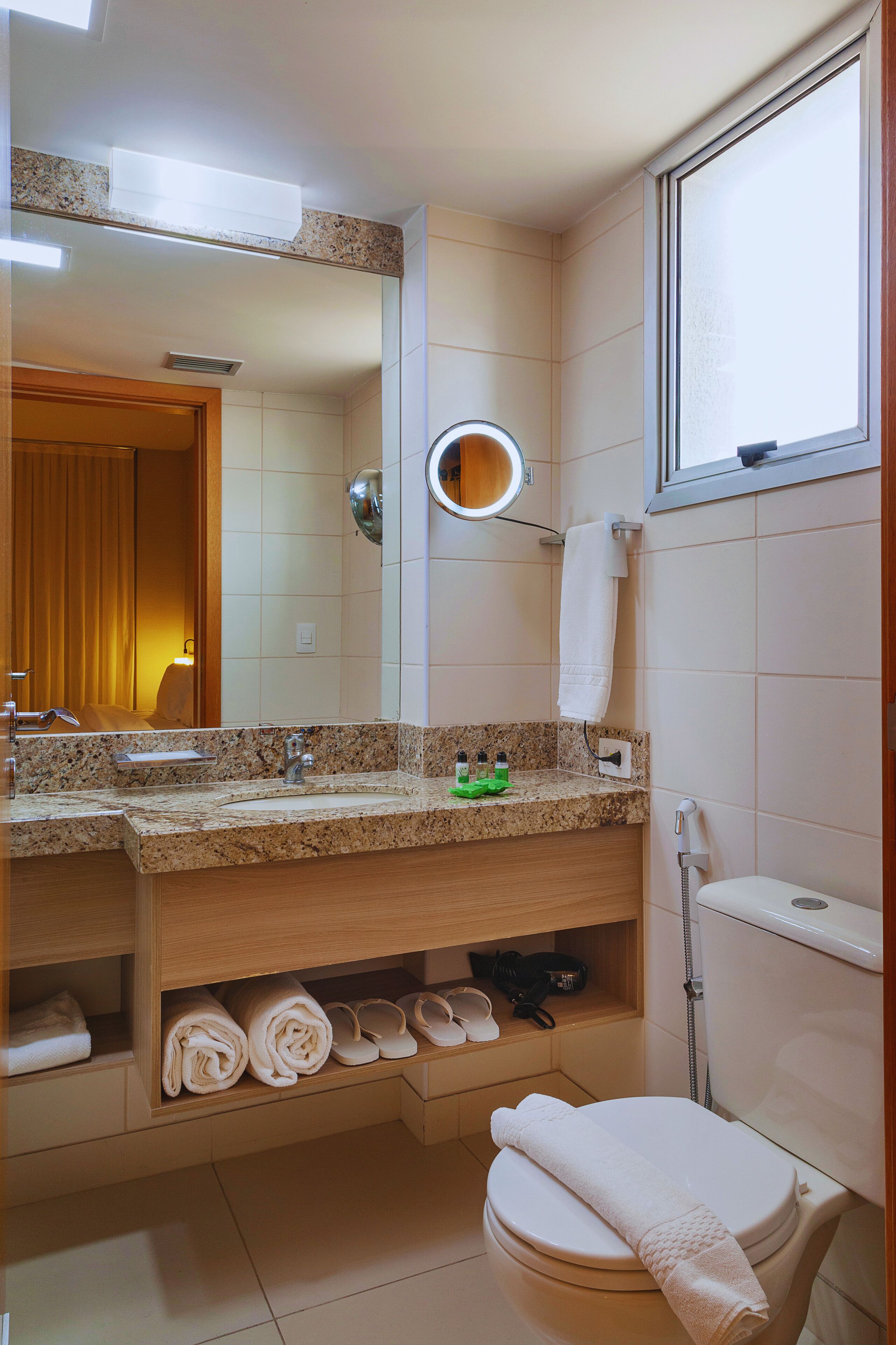 A bathroom with a sink, mirror, towel rack, and toilet.