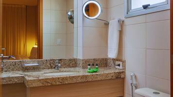 A bathroom with a sink, mirror, towel rack, and toilet.