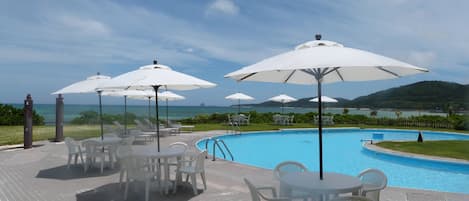 Piscine extérieure, parasols de plage, chaises longues