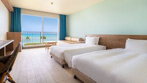 Ein Hotelzimmer mit zwei Betten, einem Schreibtisch und Blick auf den Ozean.