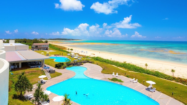 Ein Resort mit großem Schwimmbad, Strand und Meerblick.