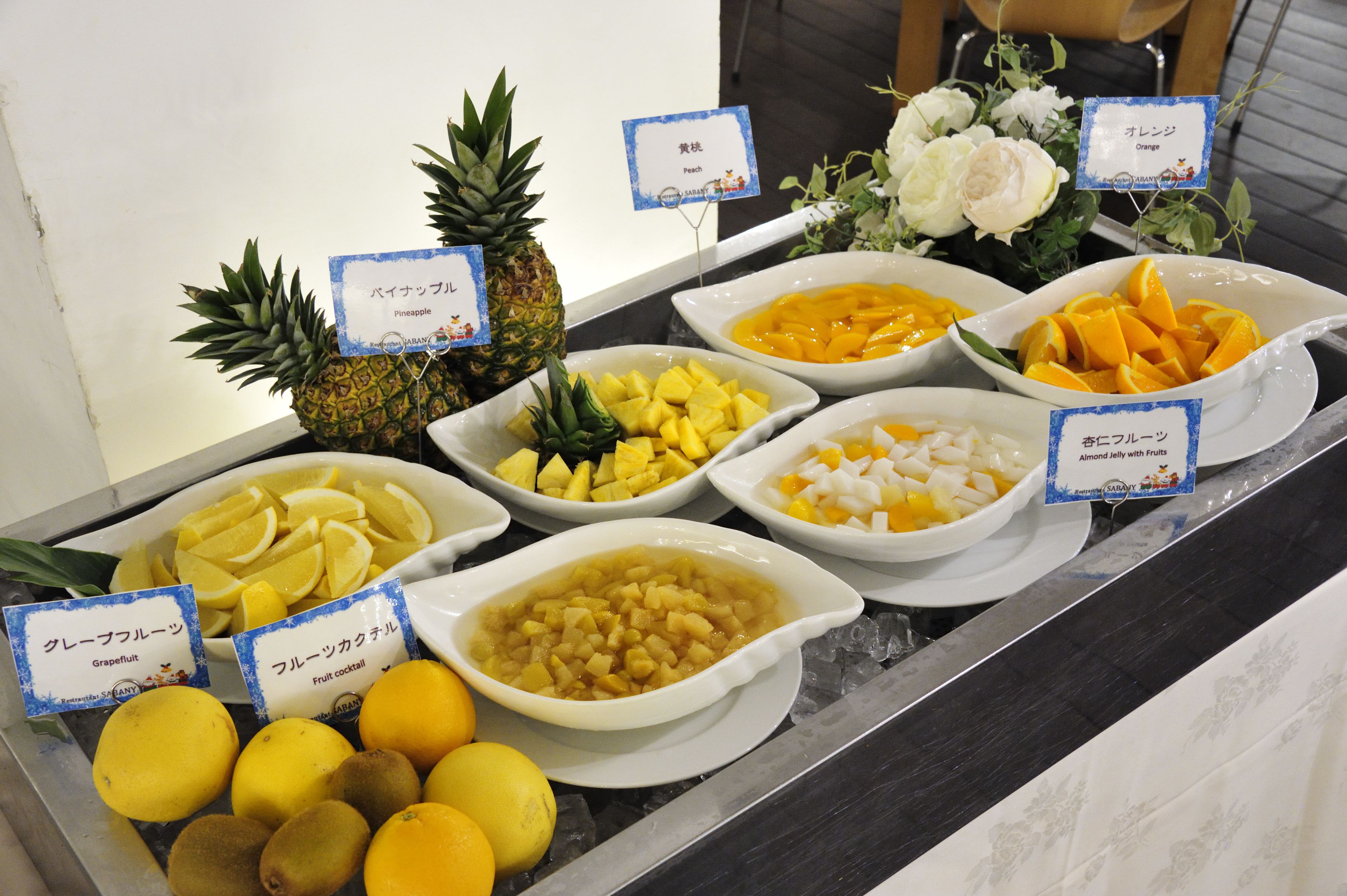 A buffet with various fruits and a pineapple.