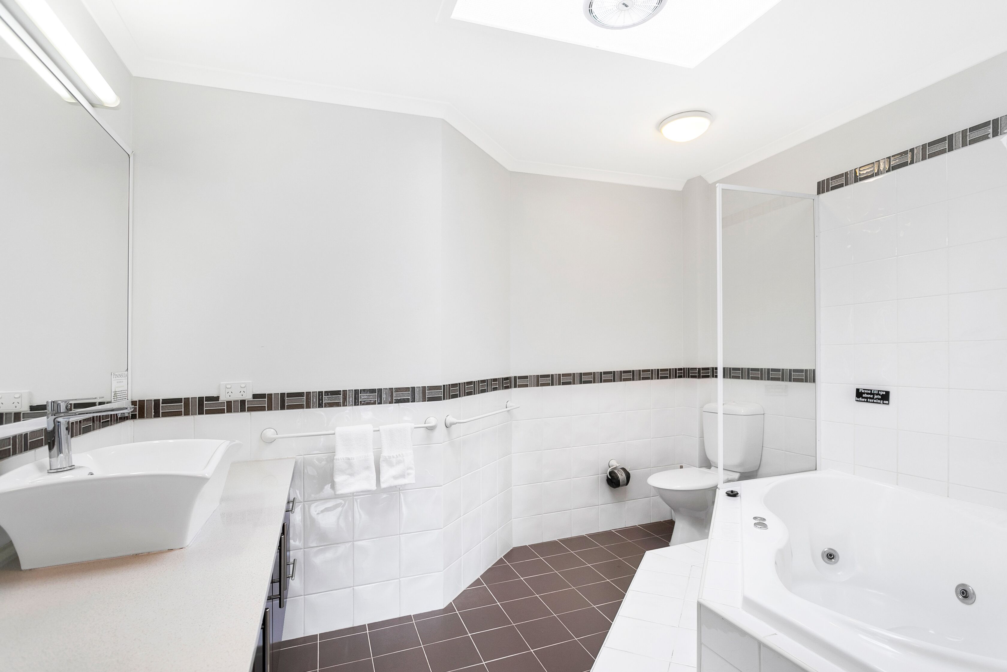 A modern bathroom with a bathtub, a shower, and a toilet.