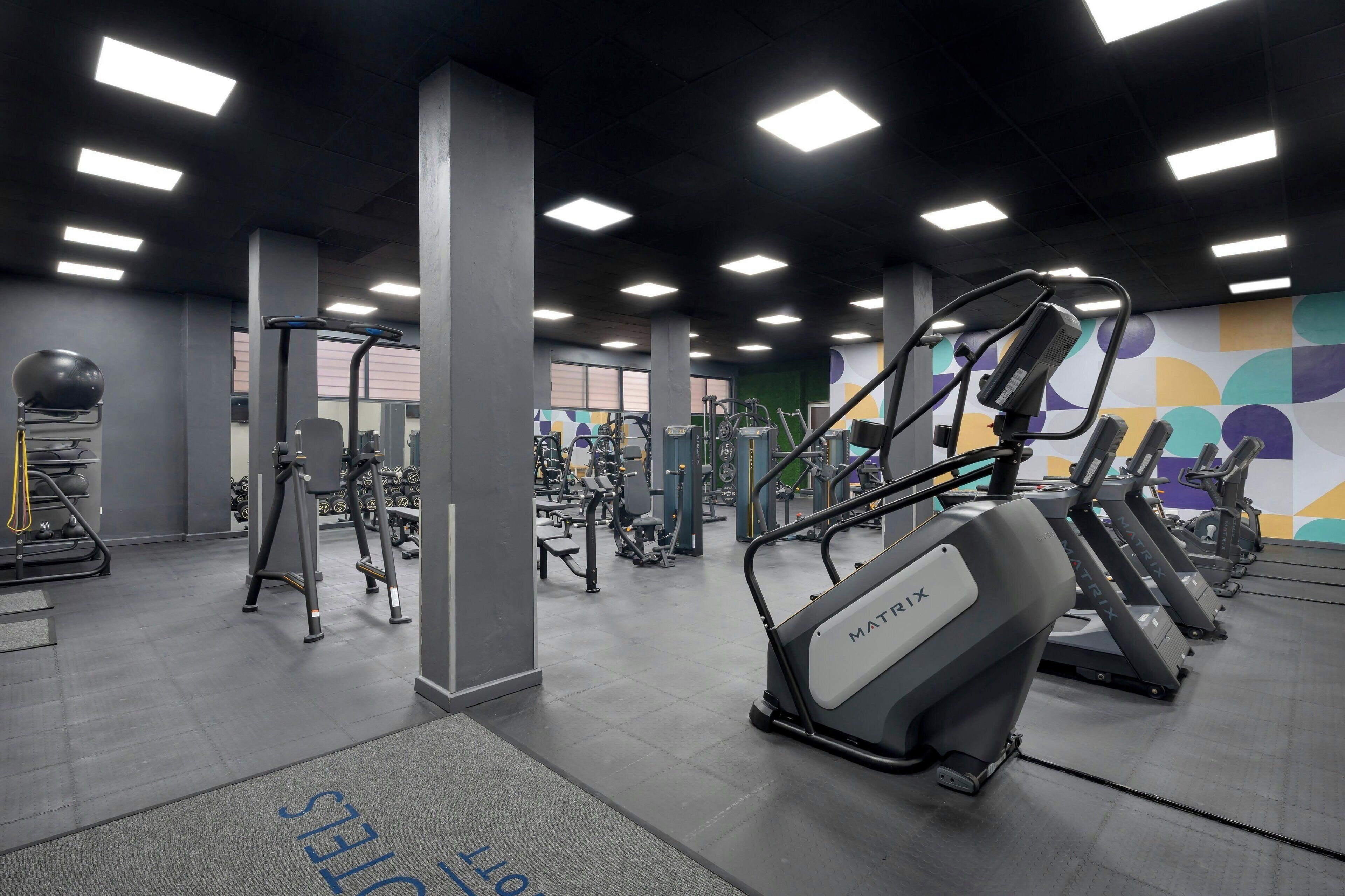 A gym with treadmills, weight machines, and exercise balls.