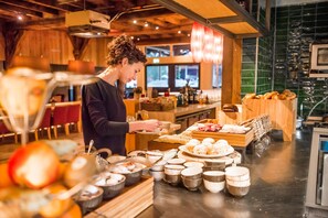 Una persona sirve comida en un restaurante con una variedad de platos y bebidas a la vista.