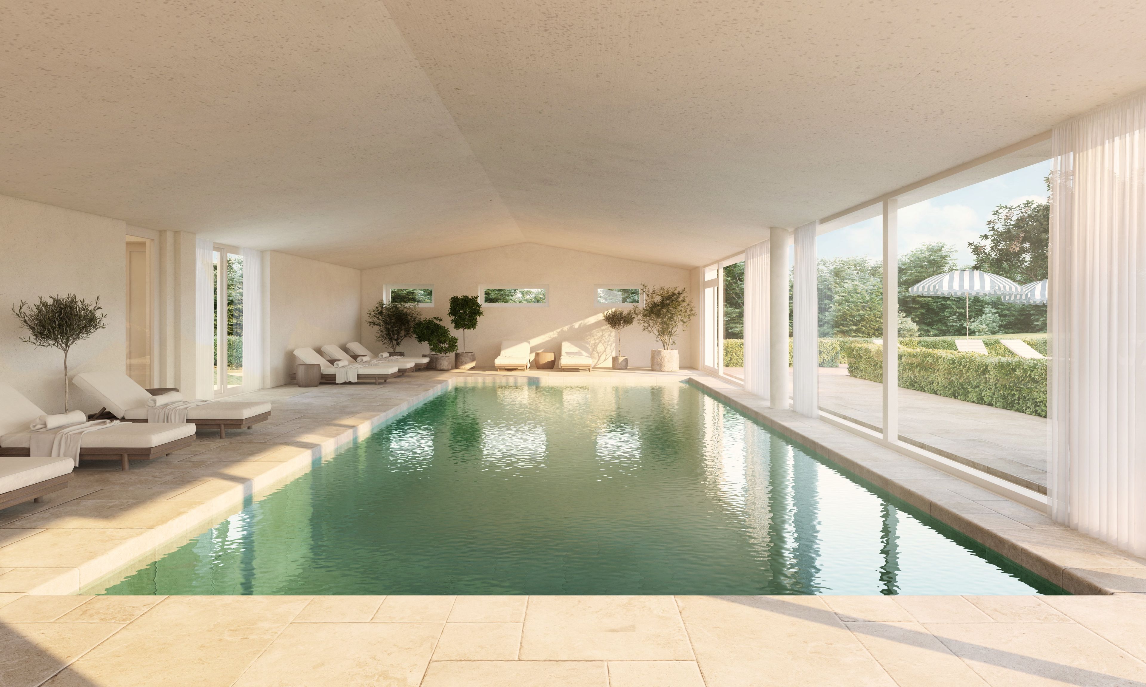 A modern indoor swimming pool with lounge chairs and large windows.